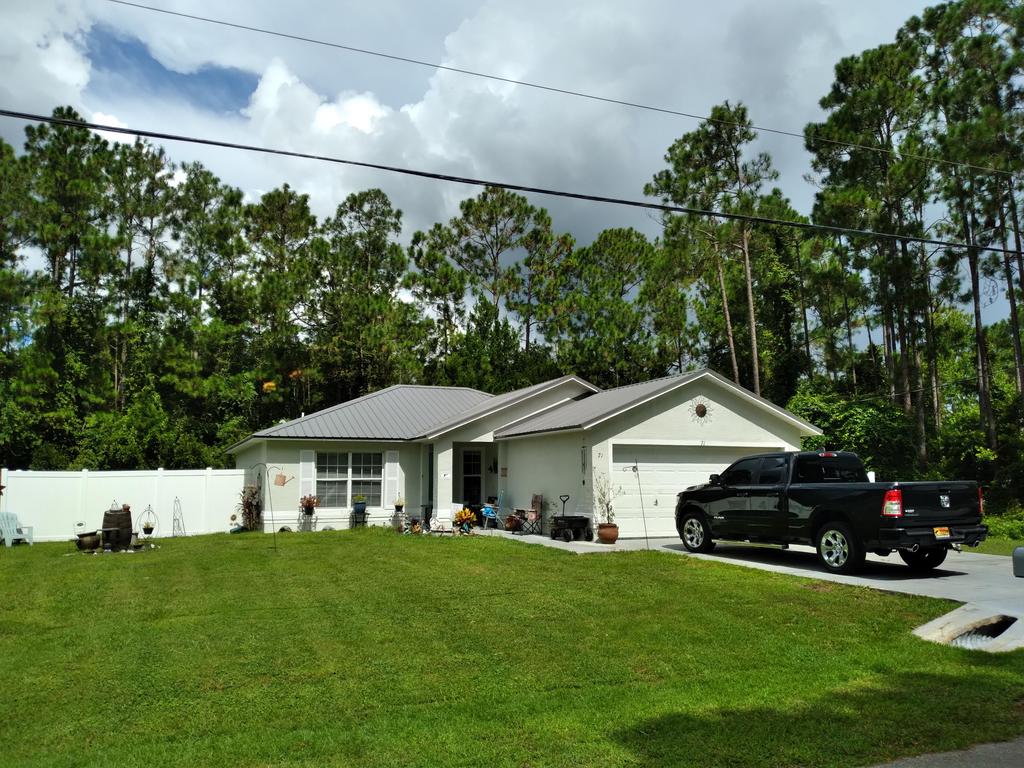 Florida home with a metal roof under gathering storm clouds