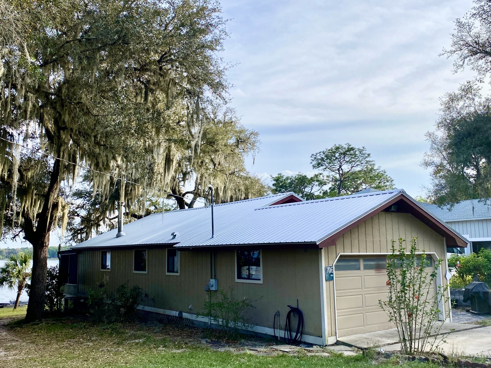 Ribbed exposed-fastener metal panel roof on a lakefront Florida home