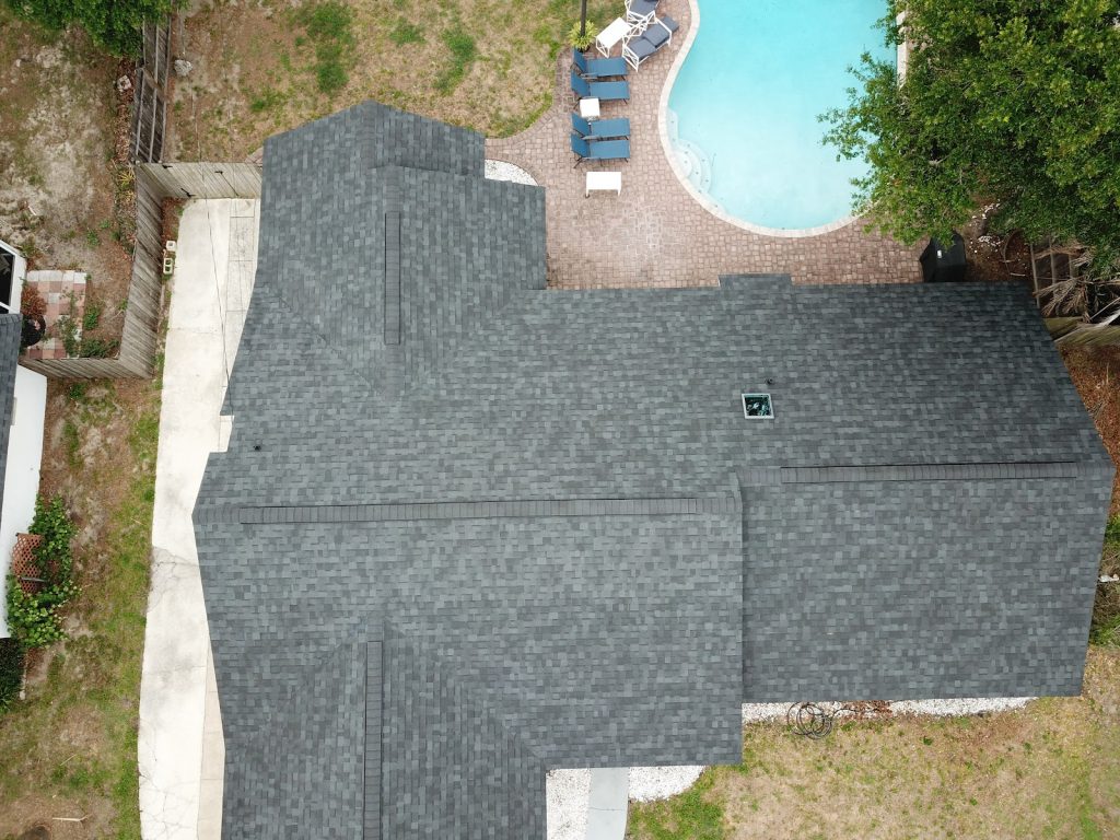 Aerial view of a charcoal architectural shingle roof with a skylight on a Central Florida pool home